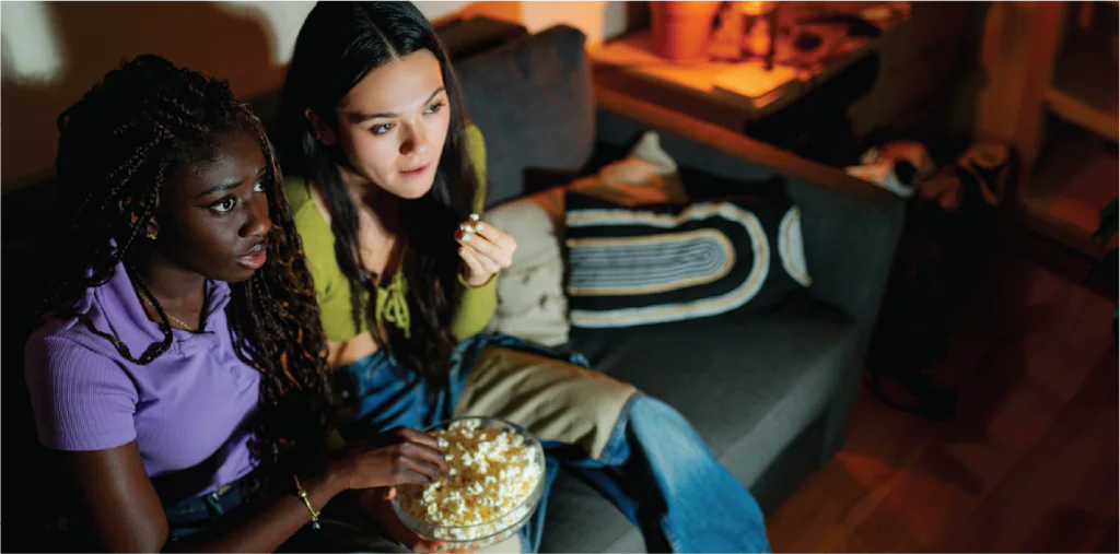 Two people watching a movie on the couch