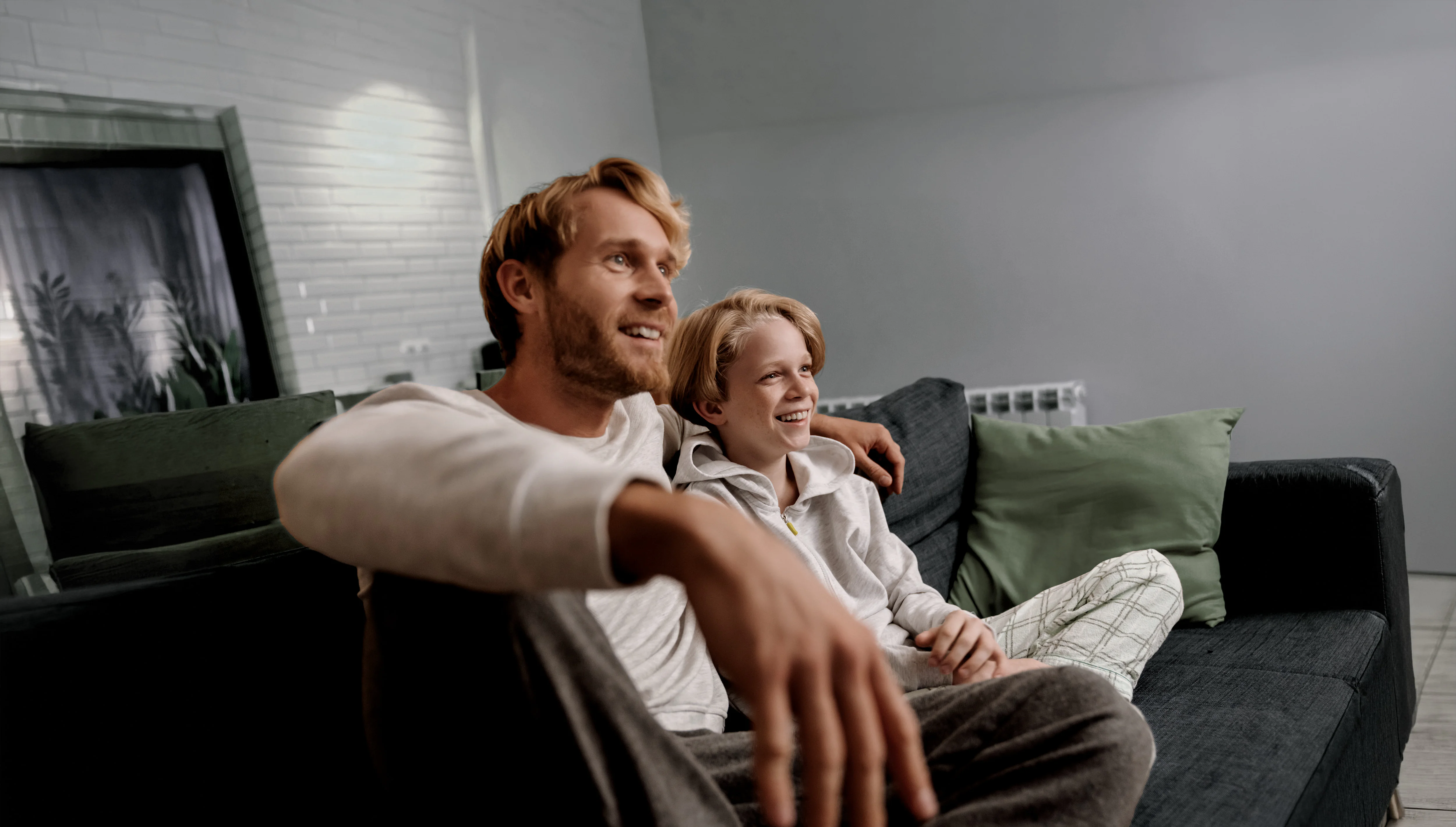 Parent and child watching TV together on the couch